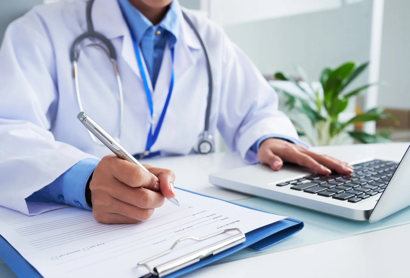Médico preenchendo a ficha de atendimento do paciente